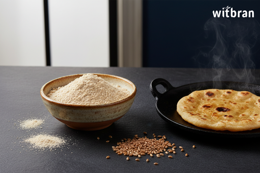 Freshly milled Witbran Khapli Atta emmer wheat flour in a ceramic bowl with scattered wheat grains and a freshly made roti on a tawa
